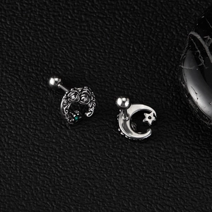 Detailed macro view of vintage silver crescent earrings with rose relief and green zircon