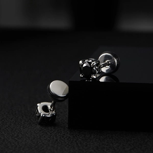 Dettaglio macro di orecchini a perno in argento con zircone nero e montatura a sei griffe