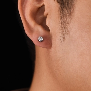 Dettaglio di un orecchino con zircone e montatura in argento indossato sul lobo