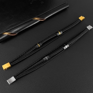 Macro detail of men's braided leather bracelets with brushed gold and silver steel clasps