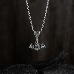 Détail du pendentif Viking Mjölnir avec symbole Valknut sur fond de pierre noire