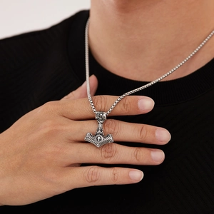 Gros plan du pendentif Mjölnir viking avec nœuds celtiques et rune Tiwaz sur chaîne