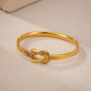 Dettaglio macro del bracciale a nodo dorato con pietre colorate e chiusura a cerniera