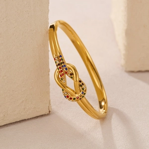 Bracciale a nodo in oro lucido con gemme multicolori su una base di pietra grezza