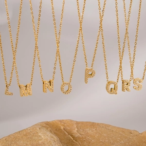Detail view of gold-plated alphabet necklaces with sparkling zircon inlaid pendants