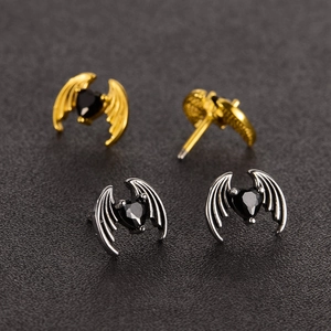 Macro shot of gothic bat wing stud earrings with heart-shaped black zircon gemstones