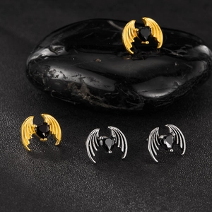 Detailed view of gothic bat wing stud earrings with black heart zircon in gold and silver