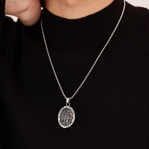 Close-up of Saint Michael pendant in vintage silver finish worn on black sweater