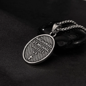 Macro view of St. Michael archangel stainless steel pendant with textured relief carving