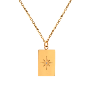 Detail view of a gold octagonal star pendant with zircon on a stainless steel chain necklace