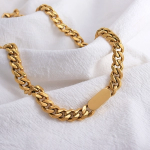 Poliertes Gold-Quadrat-Tag-Cuban-Kettenhalsband aus Titanstahl auf weißem Stoff
