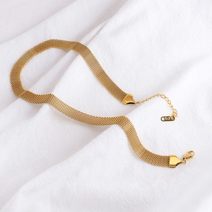 Vintage retro gouden mesh ketting met K18-label op elegante witte stoffen achtergrond