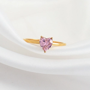 Bague élégante en titane doré avec cristal rose en forme de cœur sur soie blanche