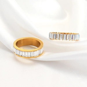 Anillos de acero de titanio dorado con cristales rectangulares sobre fondo de seda blanca