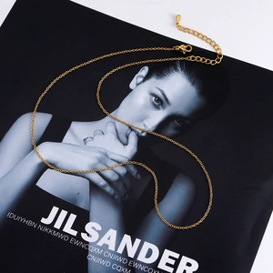 Classic gold stainless steel cable chain necklace with lobster clasp on a black background