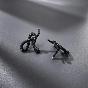 Detailed view of black snake earrings with green crystal eyes and secure screw backs