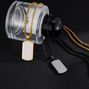Gros plan de pendentifs militaires dorés et noirs avec rayures sur chaînes en acier inoxydable