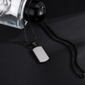 Détail macro du collier pour homme avec chaîne box noire et pendentif rectangulaire