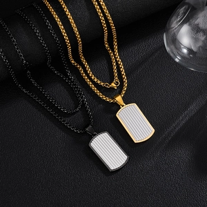 Vue détaillée de pendentifs rectangulaires pour hommes en or et noir sur cuir