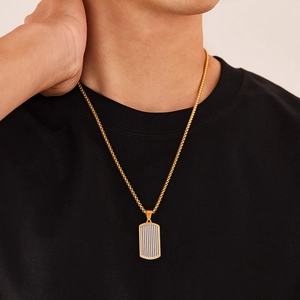 Vue rapprochée du pendentif rectangulaire bicolore pour homme avec bordure dorée