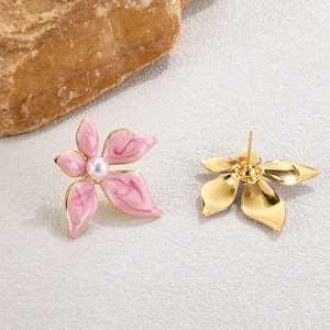 Détails des boucles d'oreilles fleur aux pétales peints en rose et perles blanches