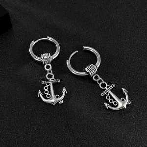 Vue détaillée des boucles d'oreilles ancre en argent avec motifs sur fond noir