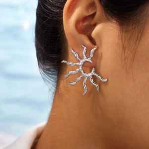 Poliertes Sonnenblumen-Ohrstecker-Design aus Edelstahl am Ohr mit flüssiger Metalloptik