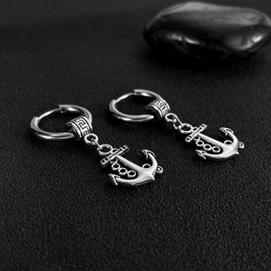 Détail macro de boucles d'oreilles ancre en argent vintage avec motif grec sur fond noir