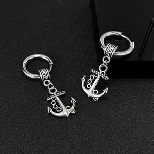 Détail macro de boucles d'oreilles ancre argentées avec motifs grecs vintage