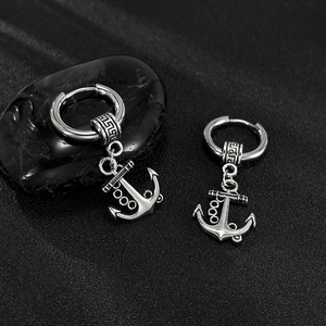 Gros plan détaillé de boucles d'oreilles ancre en argent pour hommes sur fond noir