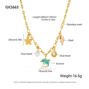 Dettaglio della collana oceano dorata con stelle marine, conchiglie e delfino smaltato blu