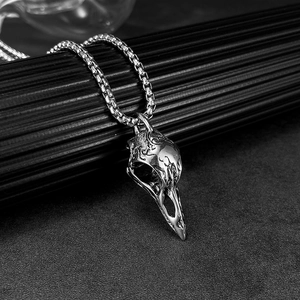 Close-up of vintage stainless steel bird skull pendant with intricate antique carvings