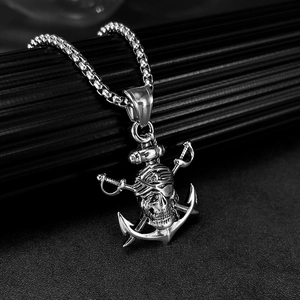 Détail du pendentif crâne argenté avec épées croisées et ancre sur chaîne à mailles