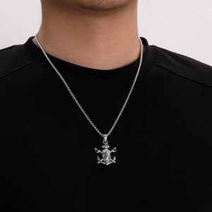 Gros plan d'un collier pour homme en acier inoxydable avec pendentif crâne de pirate
