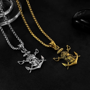 Détail de colliers avec pendentifs tête de mort pirate dorés et argentés avec ancre