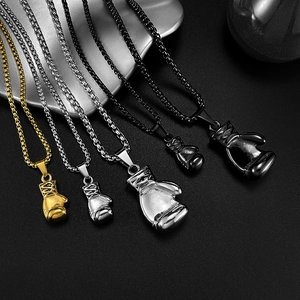 Macro shot of boxing glove pendants in gold, silver, and black finish with metal chains