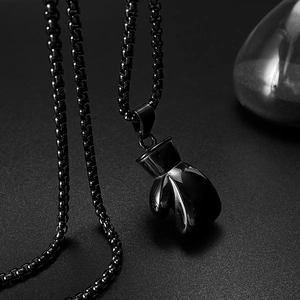 Detail of a polished black boxing glove pendant made of stainless steel with box chain