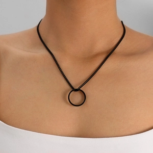Close-up of minimalist black necklace with round pendant on a model's neckline