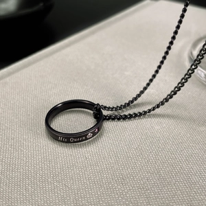 Detail of black titanium His Queen ring necklace with crown motif and pink gemstone