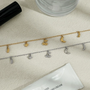 Detailansicht der gold- und silbernen Fußkettchen mit Mond- und Kirsch-Anhängern