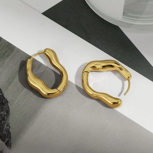 Details von hochglanzpolierten goldenen unregelmäßigen Wellenohrringen mit Lava-Textur