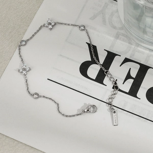 Detailed close-up of a stainless steel clover bracelet with sparkling cubic zirconia