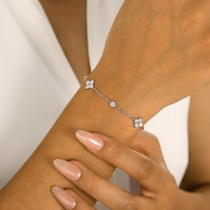 Elegant stainless steel bracelet with zircon clover and round charms on a female wrist