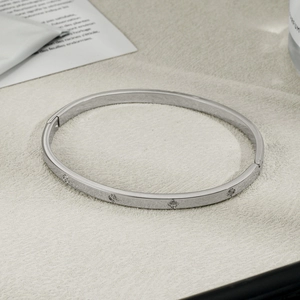 Detail of silver stainless steel bangle with quatrefoil cubic zirconia and hinge clasp