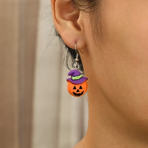 Detailed view of resin Halloween pumpkin earrings with a purple wizard hat on ear