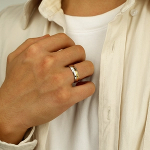 Gros plan détaillé sur une bague tricolore en acier avec gravure Roses are red