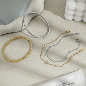 Elegant gold and silver stainless steel clover bracelet set with sparkling cubic zirconia