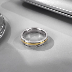Vue macro d'une bague bicolore en acier inoxydable avec bande dorée mate et diamant