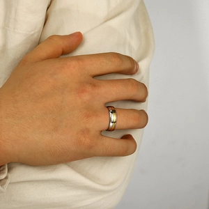 Détail d'une bague de couple bicolore en acier inoxydable avec zircon et gravure