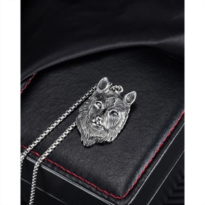 Detailopname van een roestvrijstalen wolfskop hanger aan een stevige vierkante schakelketting